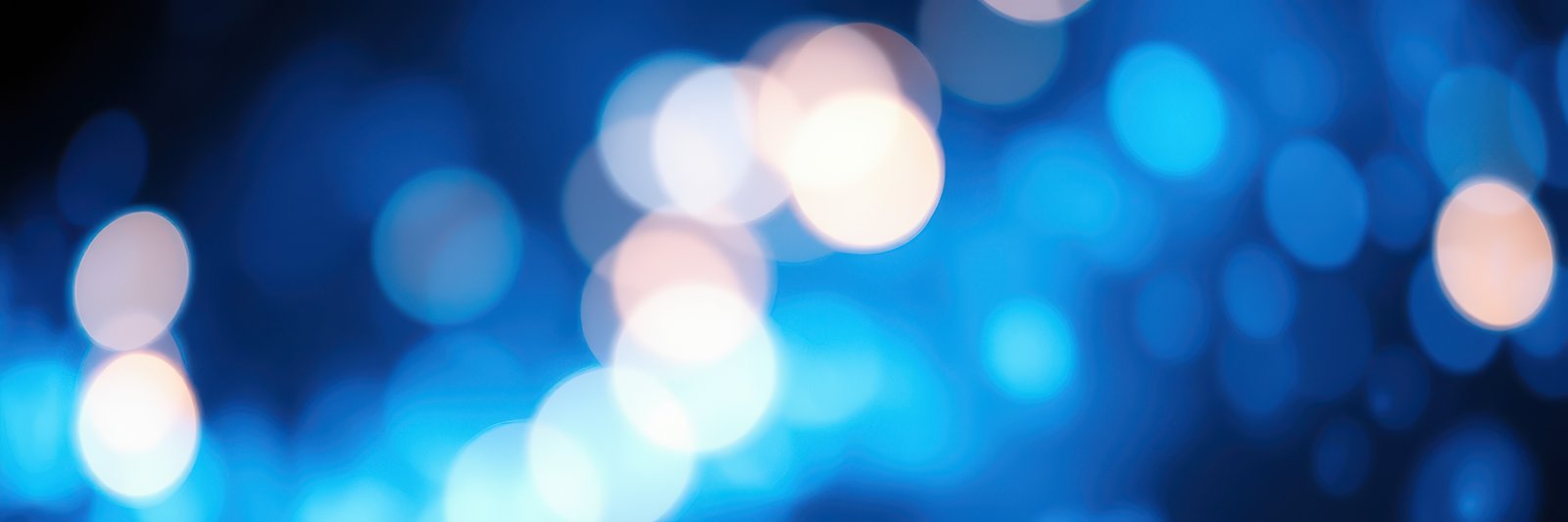 Vibrant blue and white bokeh lights create a captivating background during an evening event in an urban setting